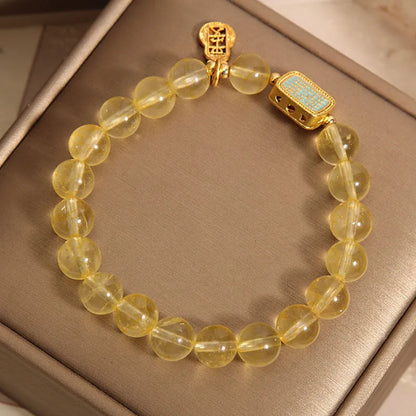Women's bracelet made from yellow citrine crystal with rhinestone decoration on a white background.