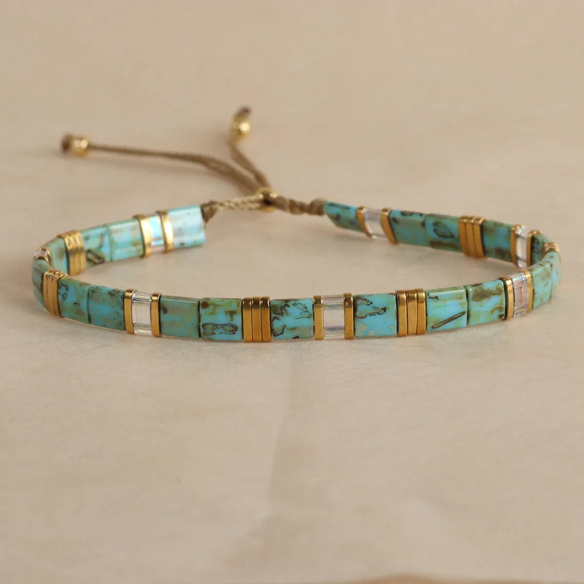 Adjustable pull beads glass bracelet in geometric shapes, shown in milky white colour.