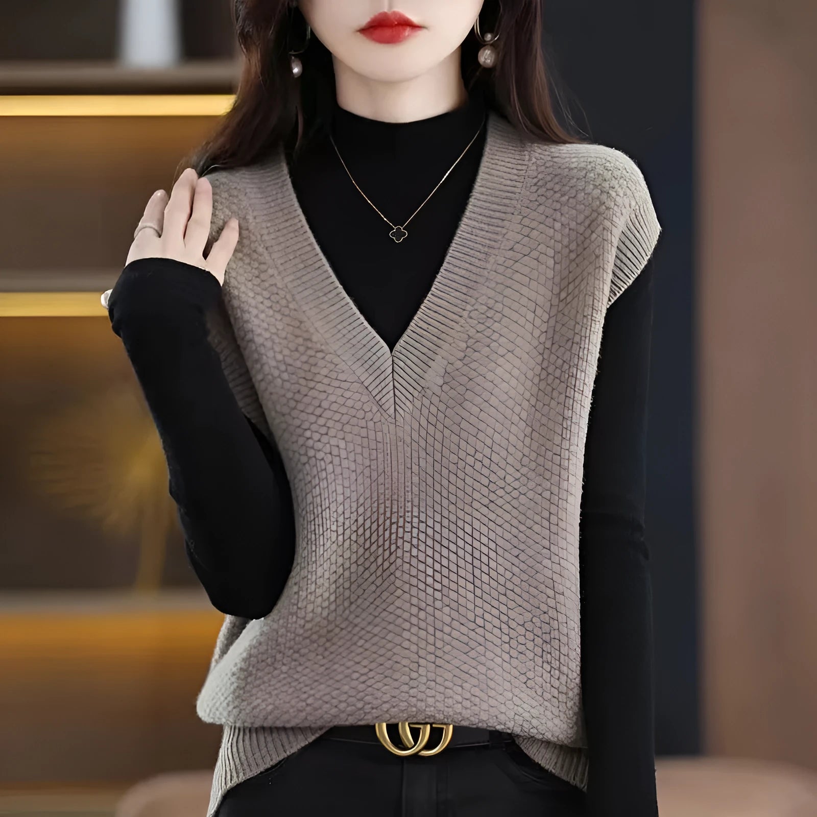 Women's creamy-white sleeveless knit vest with a raised 3D pattern, shown on a hanger.