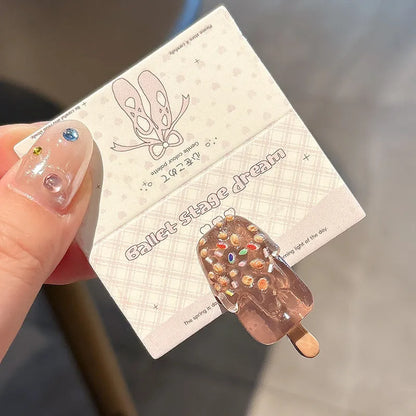A resin hair barrette with a cartoon ice cream charm on a side-clip, shown in a pink colour variant.