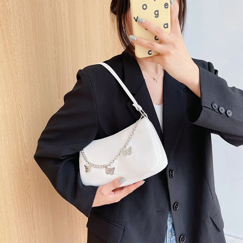 Women's black PU leather chain crossbody bag with butterfly clasp and structured square silhouette