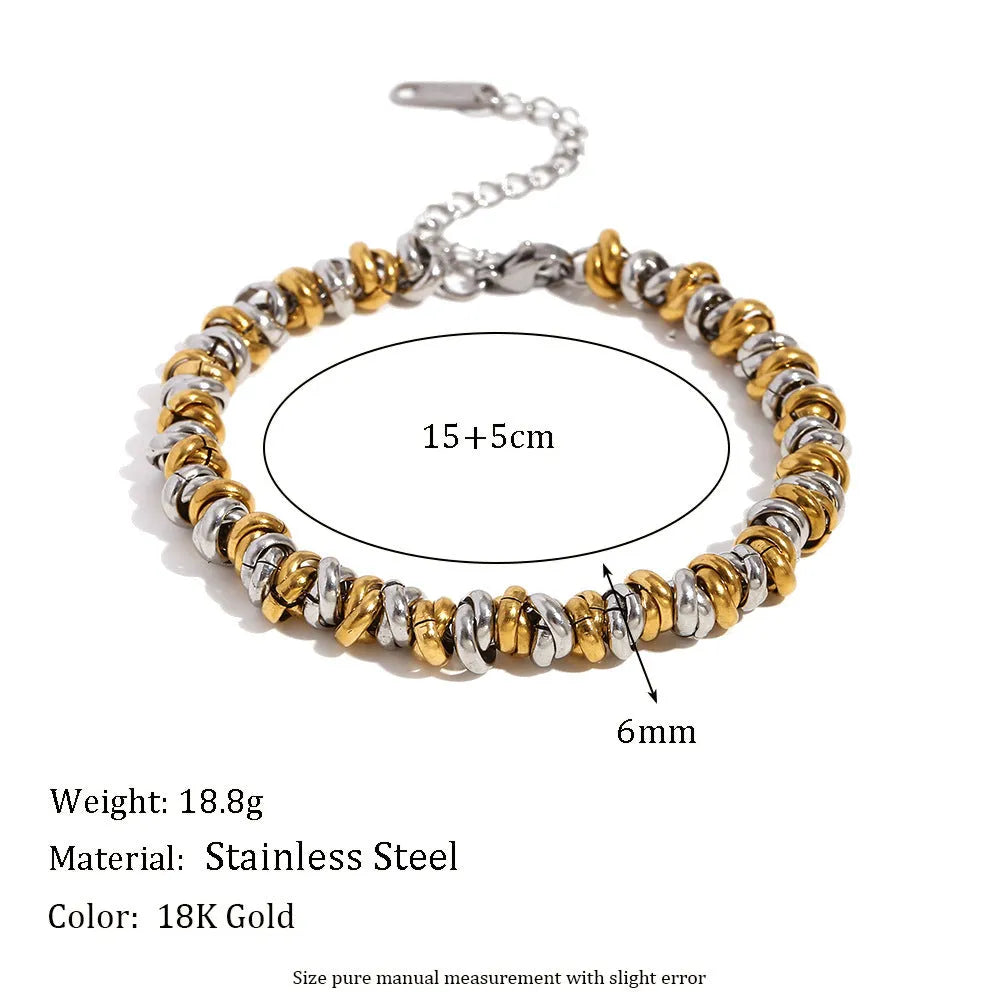 Gold electroplated stainless steel earrings, necklace, and bracelet set with geometric shapes and round ring elements