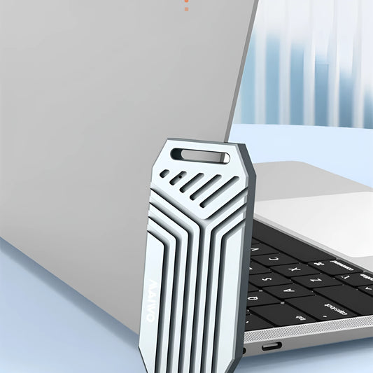 Silver aluminium Thunderbolt 4 external SSD enclosure for M.2 drives, shown next to a MacBook.