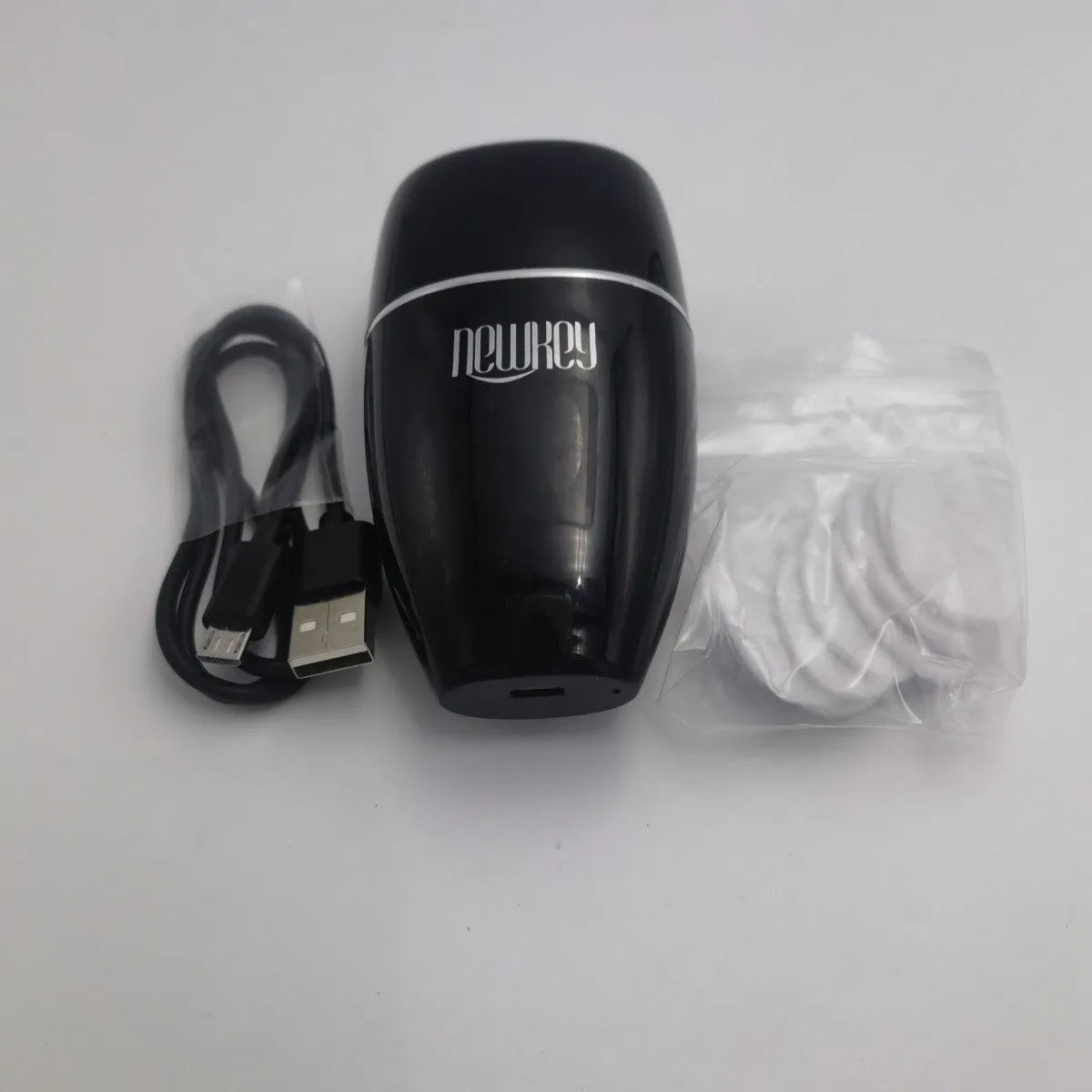 Black and white electric lip plumper device with silicone tip and USB cable