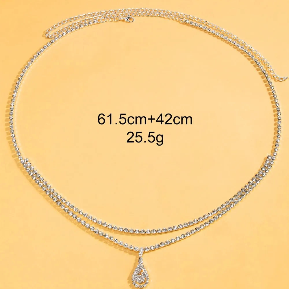 Gold water drop pendant waist chain with tassel detail and lobster buckle closure on white background