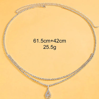 Gold water drop pendant waist chain with tassel detail and lobster buckle closure on white background