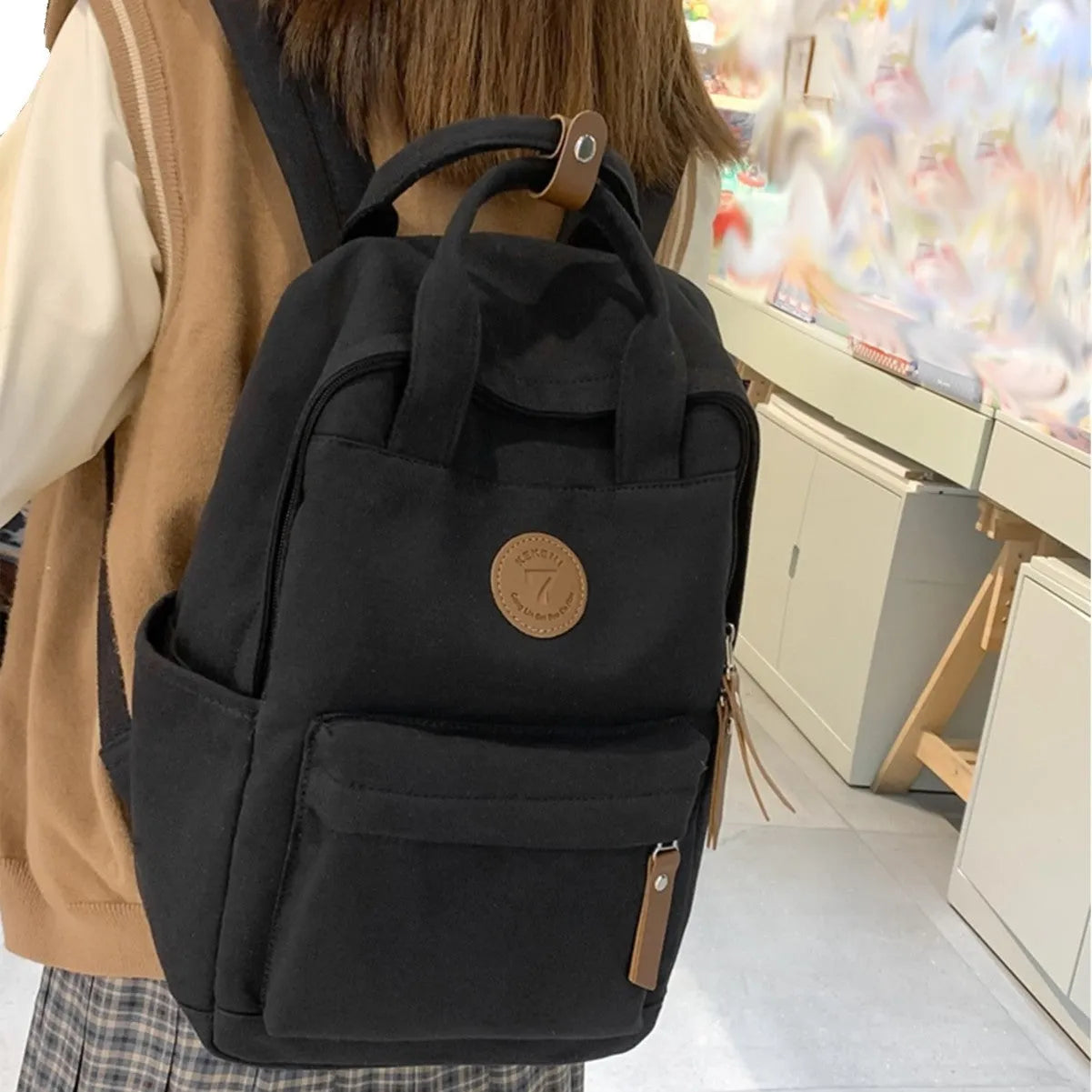 Black Oxford cloth fashion backpack with curved shoulder straps and retro sewing details