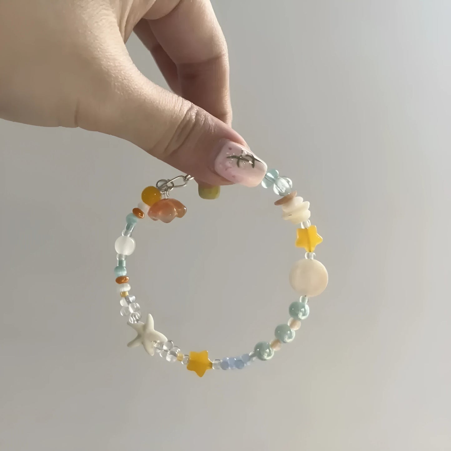 Women's orange mixed material bracelet with a diamond shape and round decorative elements.