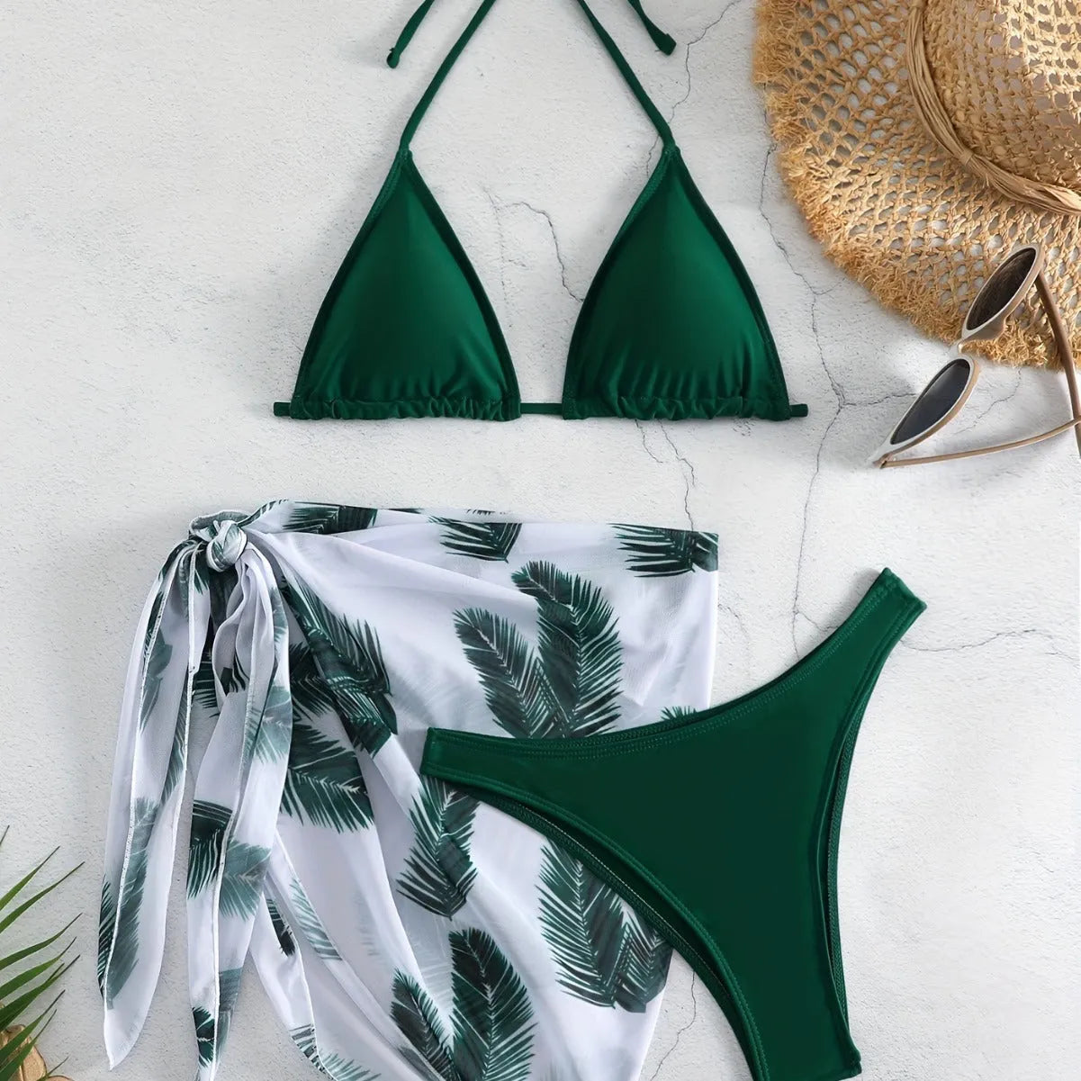 Women's orange three-piece bikini swimsuit with a matching printed gauze skirt laid flat.