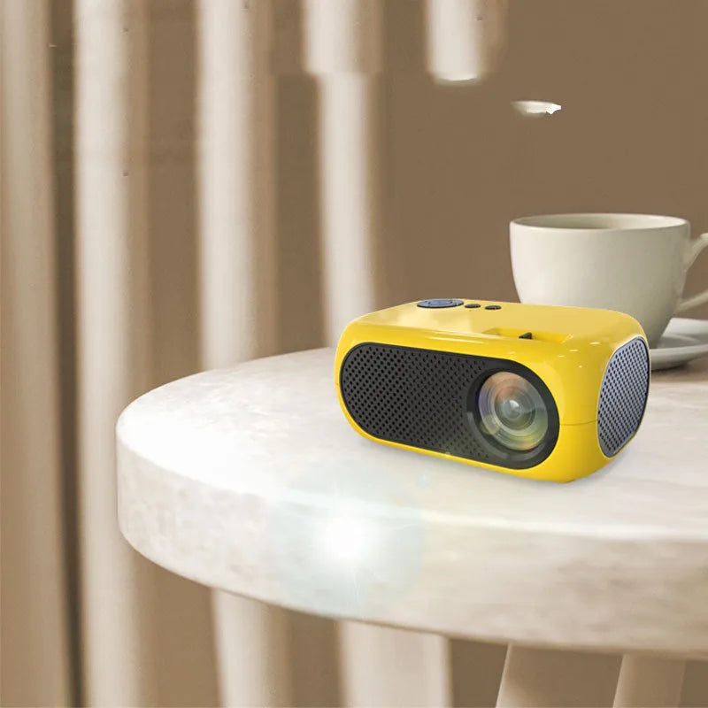 M24 gold and white portable mini LED projector with remote on a wooden table.