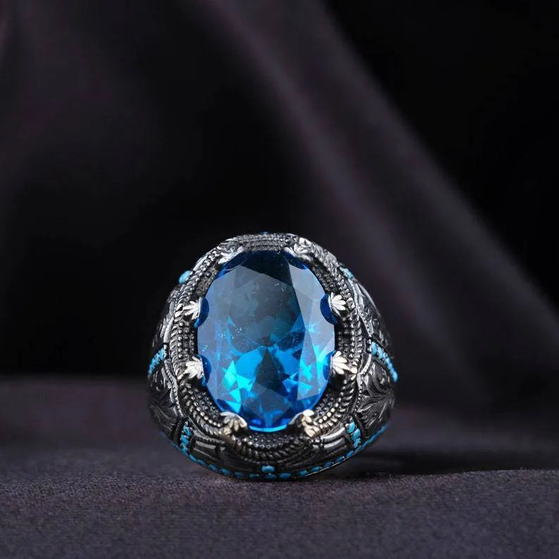 Close-up of a blue zircon geometric grandmother ring in antique silver on a finger.