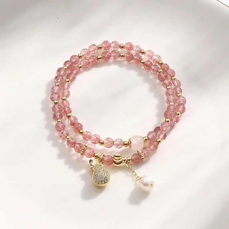 Women's geometric strawberry quartz crystal bracelet with a silver wallet money charm.
