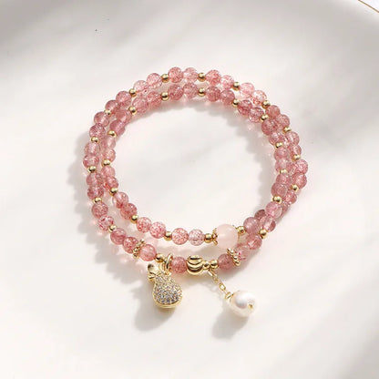 Women's geometric strawberry quartz crystal bracelet with a silver wallet money charm.
