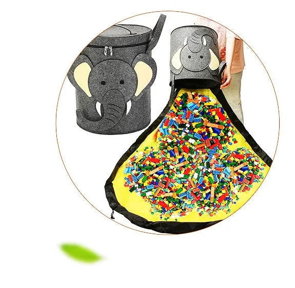 Green felt storage cube with pull rope unfolded into a large square play mat on a wooden floor.