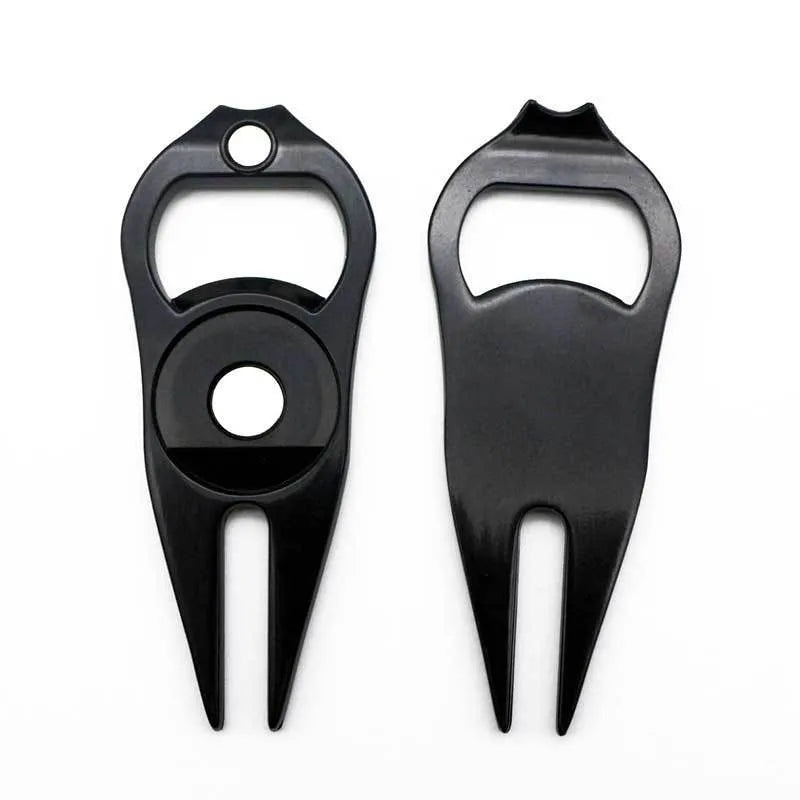 A black zinc alloy golf ball yoke tool with a bottle opener and a separate ball coin on a putting green.