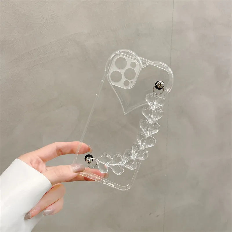 Transparent TPU iPhone case with love bracelet and heart chain design on a table.