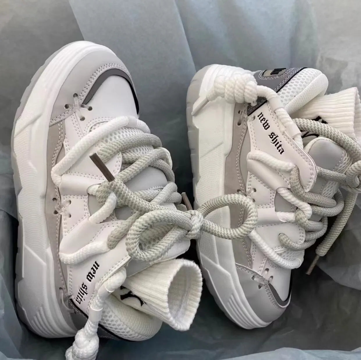 Women's grey chunky platform sneakers with white thick rubber sole and lace-up front.