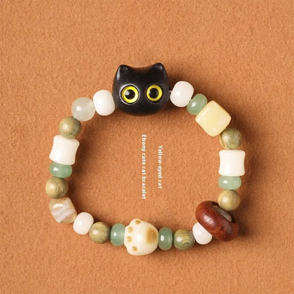 Hand-woven multi-treasure bracelet with jade, bodhi and ebony wood beads and a cartoon cat's paw charm.