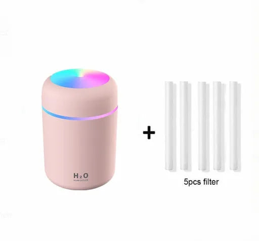 Pink car air purifying humidifier with LED lights on, next to a USB cable.