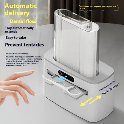 Dark grey automatic electric dental floss box with pop-up mechanism on a bathroom counter.