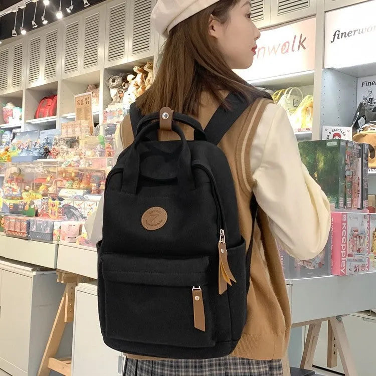 Black Oxford cloth fashion backpack with curved shoulder straps and retro sewing details