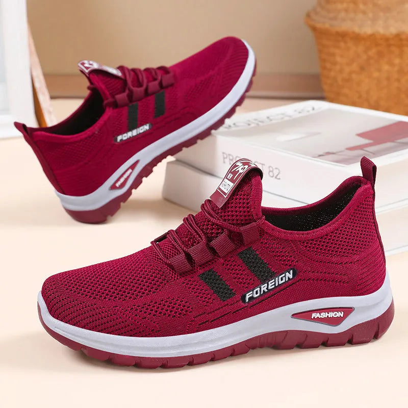 Low-top casual shoes with mesh upper and flat PVC sole in black, grey, purple, or red.
