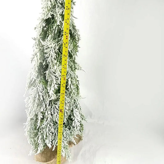 Small 24-inch green desktop Christmas tree with built-in snow sprayer and warm white LED lights on a plastic stand.