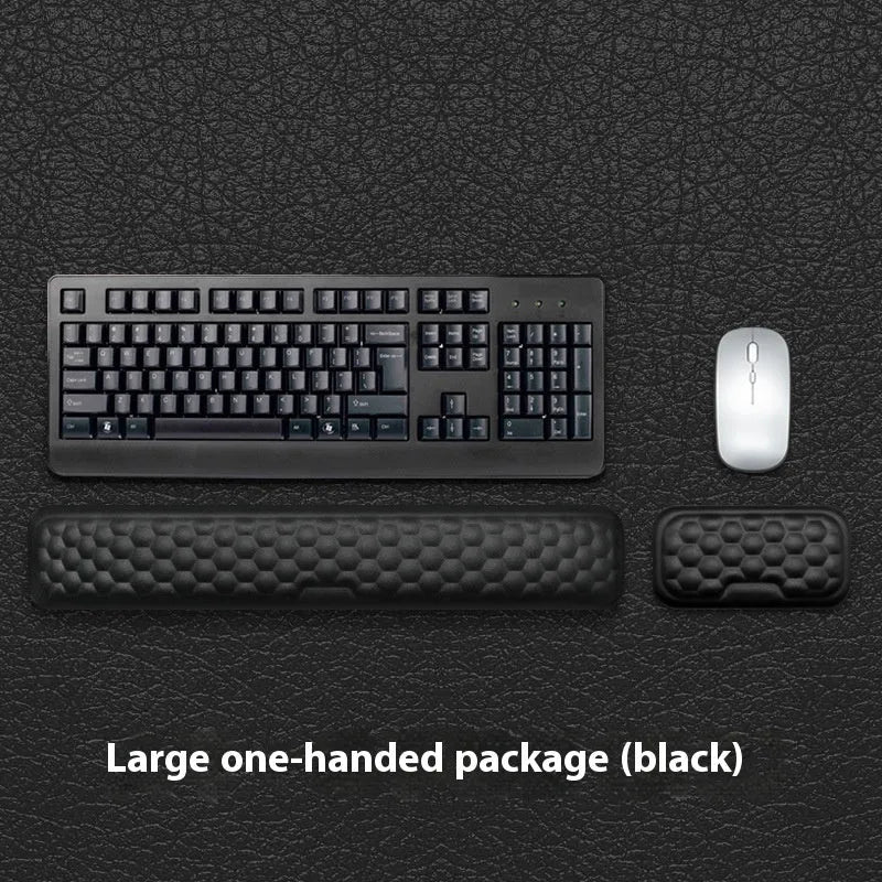 Black and grey memory foam mouse wrist rests with cloth and leather-style covers on a desk.