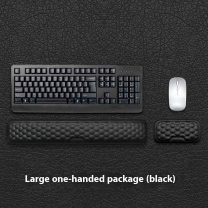 Black and grey memory foam mouse wrist rests with cloth and leather-style covers on a desk.