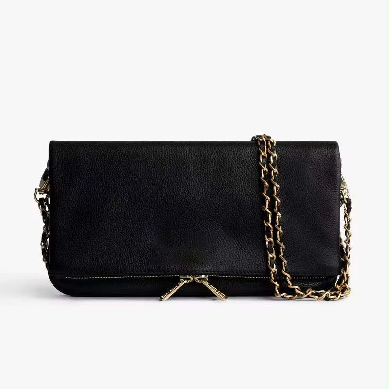 Soft black PU leather women's clutch bag with a gold chain strap, shown held and worn cross-body.