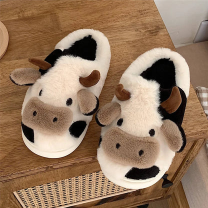 White cow-themed plush slippers with a non-slip textured sole for women.