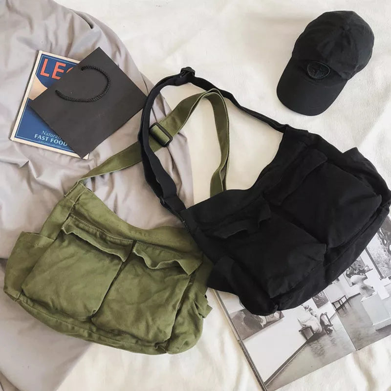 Canvas messenger bag in black, white, green, and brown with multiple pockets and adjustable strap