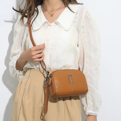 Women's genuine leather square shoulder bag in black, shown from front, displaying structured horizontal shape.