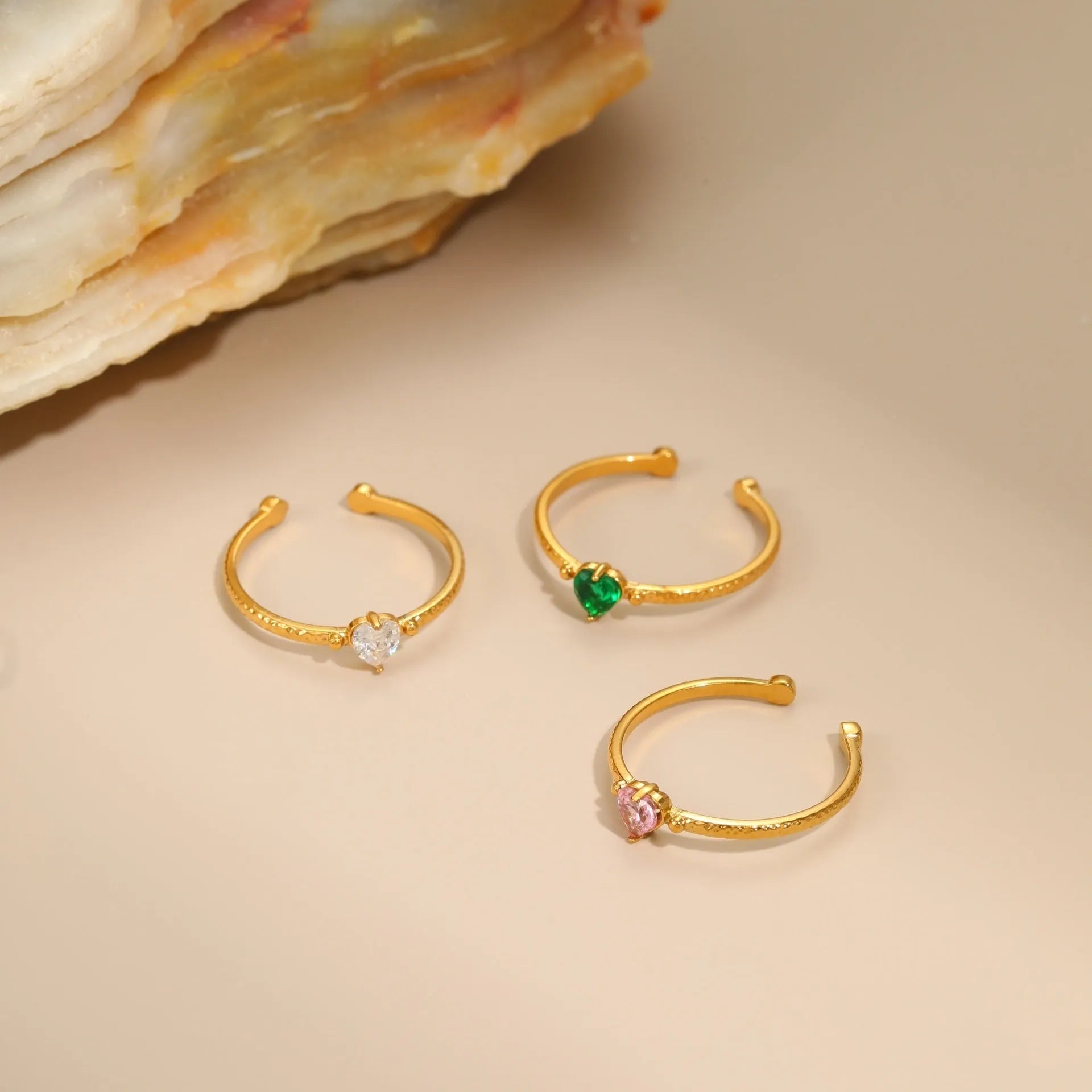 Open-ended stainless steel ring with geometric love heart shape and inlaid green zircon stone.