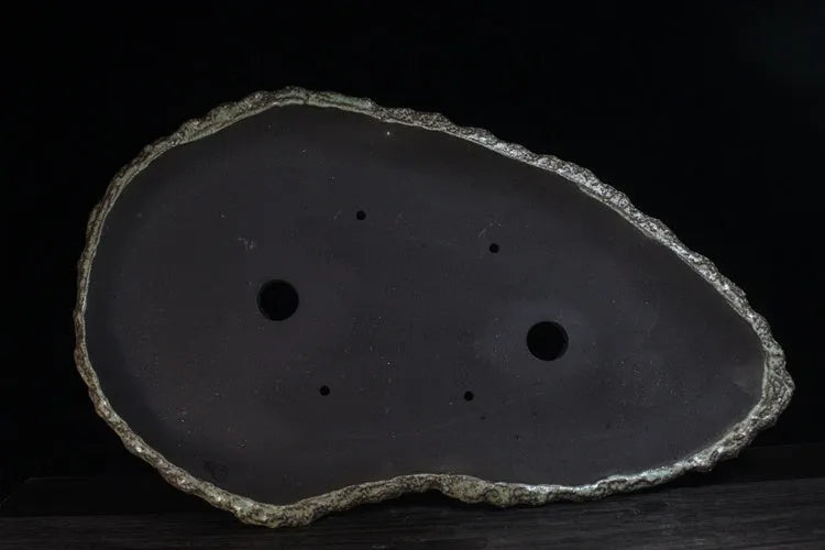 Handmade purple clay flower pot with unique shape showing natural ceramic texture
