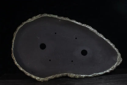 Handmade purple clay flower pot with unique shape showing natural ceramic texture