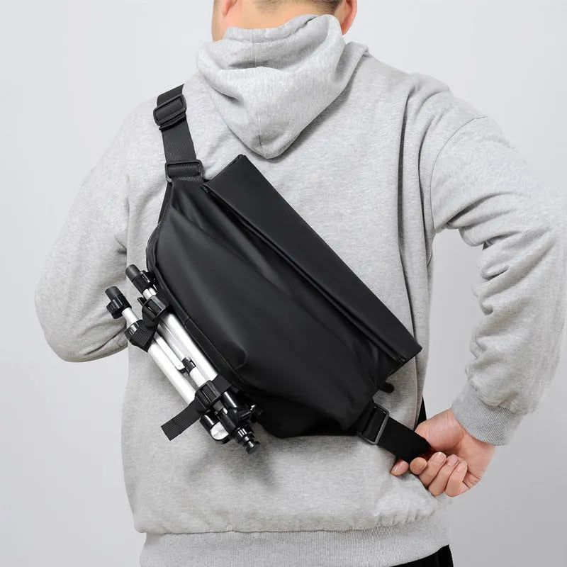 Grey crossbody bag with single shoulder strap showing zipper opening and internal organisation pockets