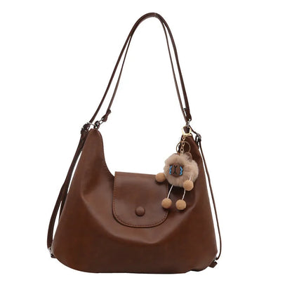 Textured PU leather women's shoulder bag in black with single strap and optional pendant