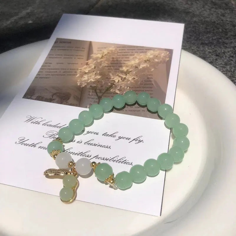 Chinese style glass bead bracelet with bamboo joint design on wrist.