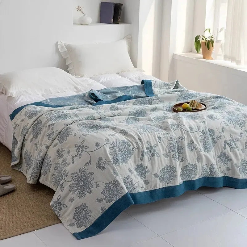 Pure cotton five-layer gauze bedspread blanket in Roulette Wheel Blue pattern on a bed.