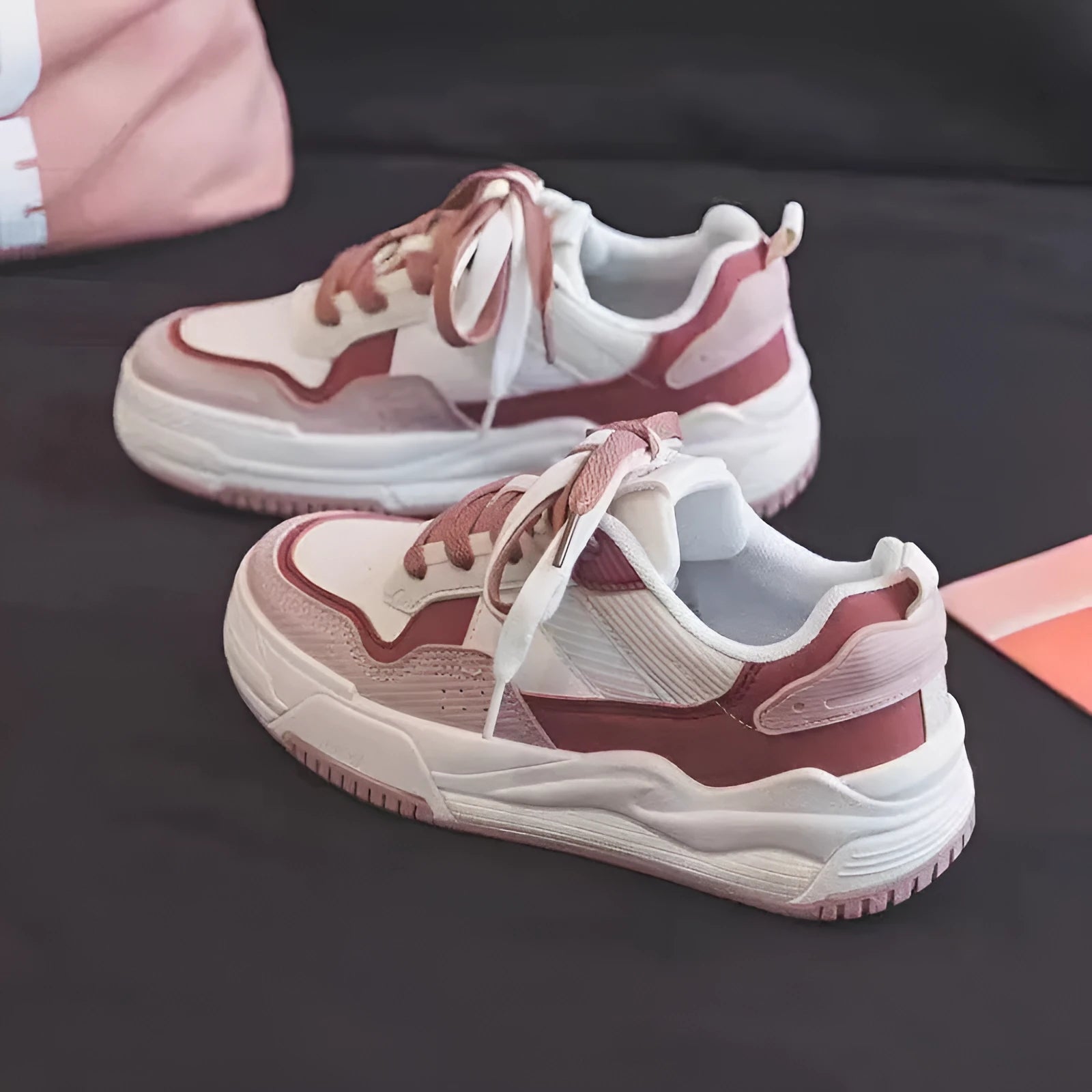 Women's beige and pink low-top sneakers with a rubber sole featuring hidden height increase.
