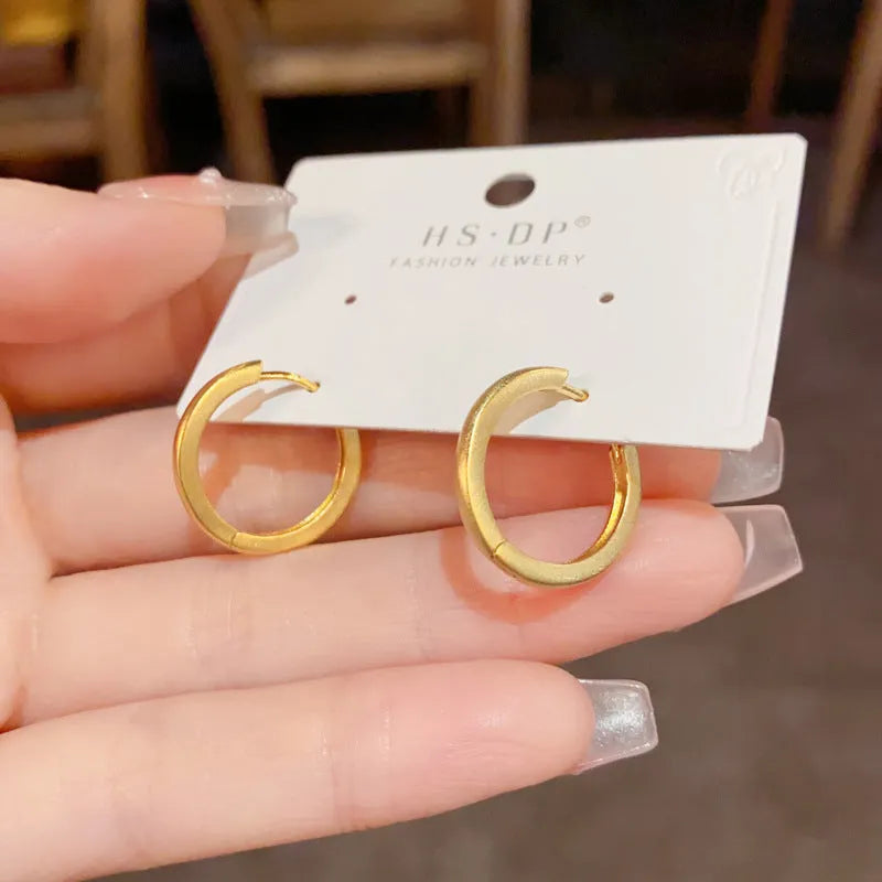 Geometric women's ear clip with round eyelet design in gold or silver colour