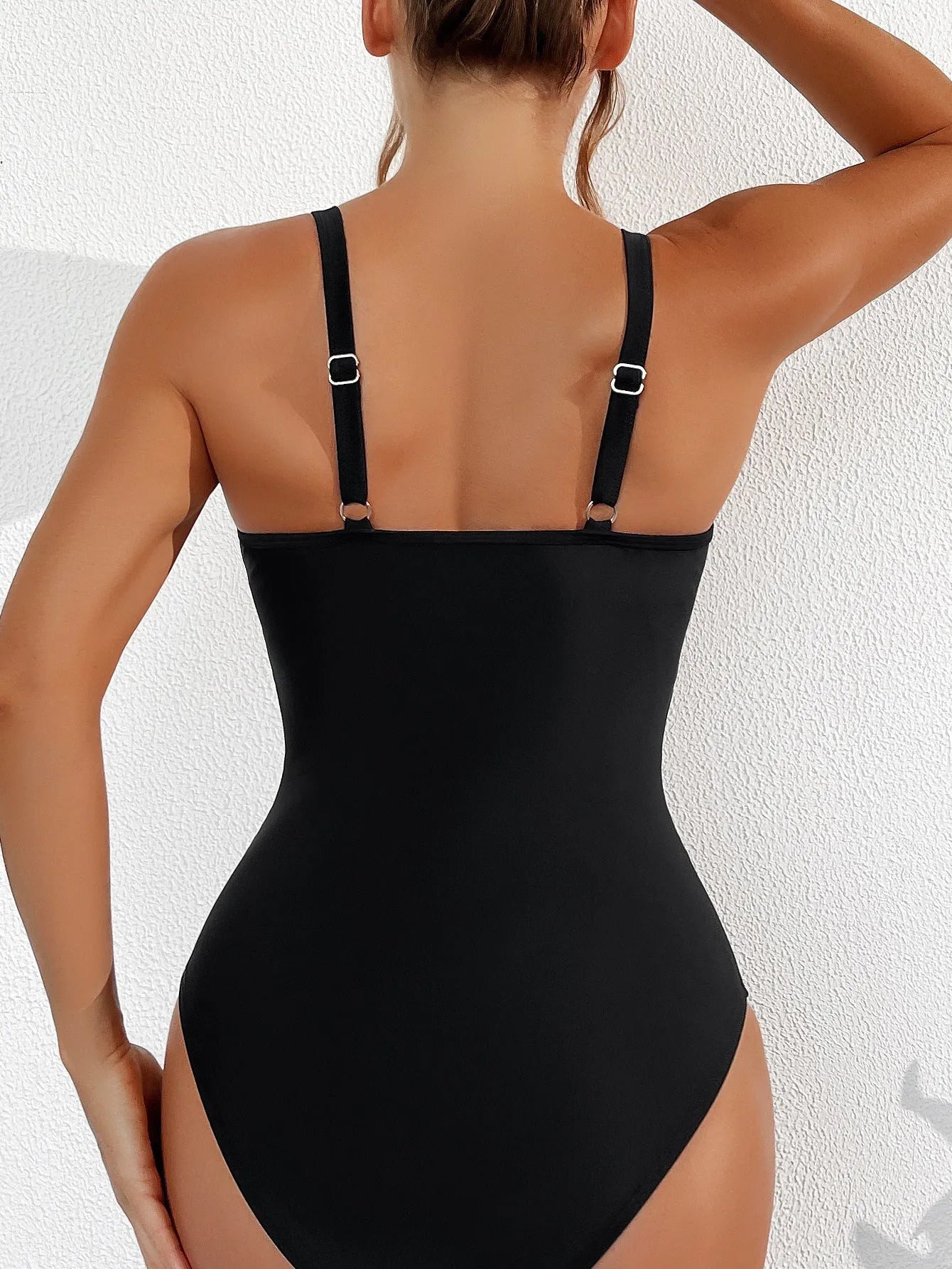 Black halter neck one-piece swimsuit with mesh panels, shown on a model.
