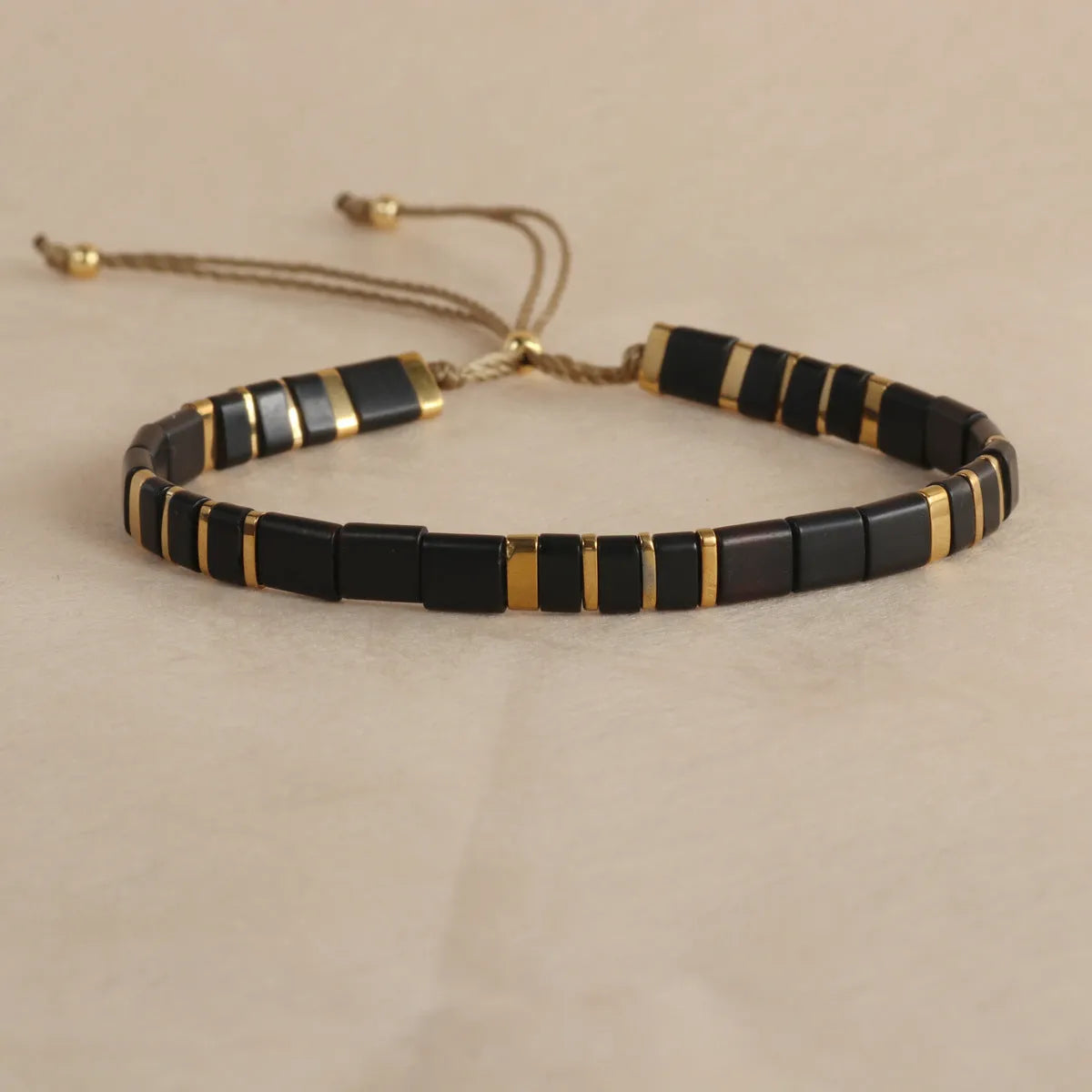 Adjustable pull beads glass bracelet in geometric shapes, shown in milky white colour.