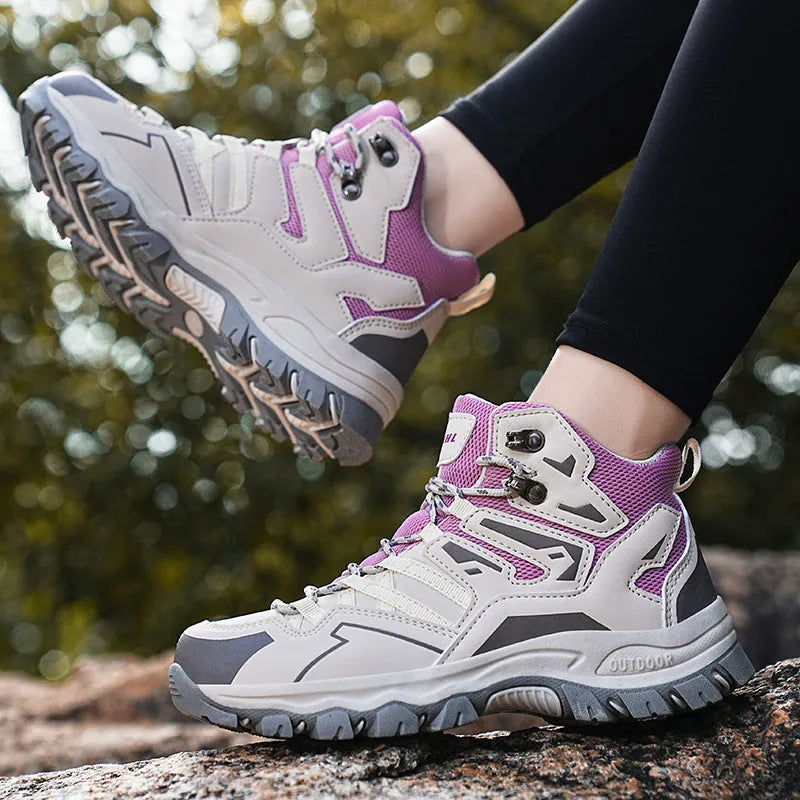 Low-top hiking sneaker in multiple colours on a rocky mountain path, showing lace-up front and rubber sole.