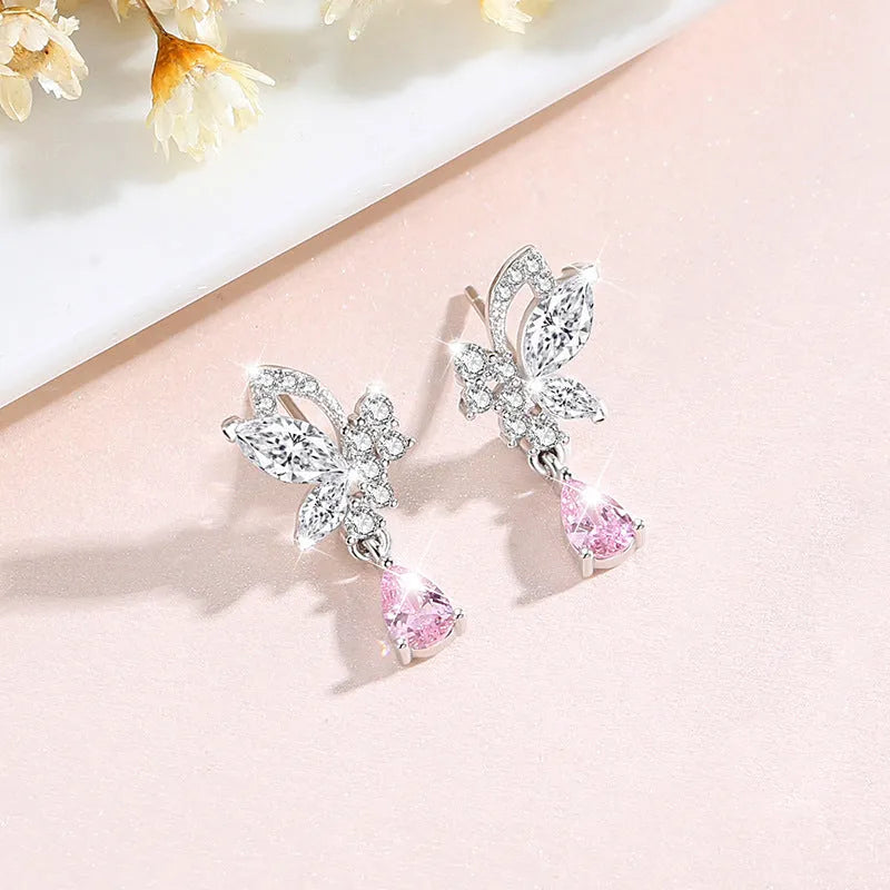 Butterfly shaped silver stud earrings with crystal details on white background