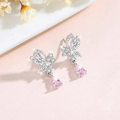 Butterfly shaped silver stud earrings with crystal details on white background