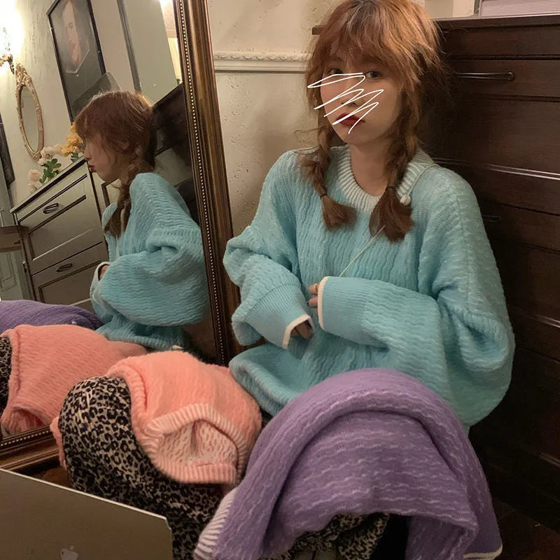 Women's loose blue pullover sweater with regular sleeves, shown on a hanger.