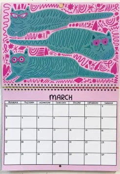 Cat-themed paper wall calendar for 2024 or 2025 year, showing monthly grid with feline artwork.