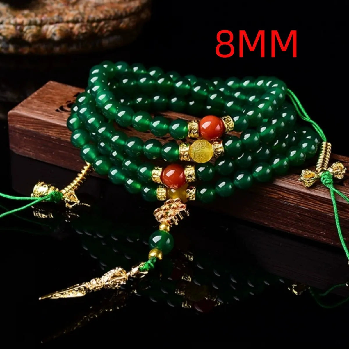 Close-up of a multi-strand green agate bracelet with natural stones on a wrist.